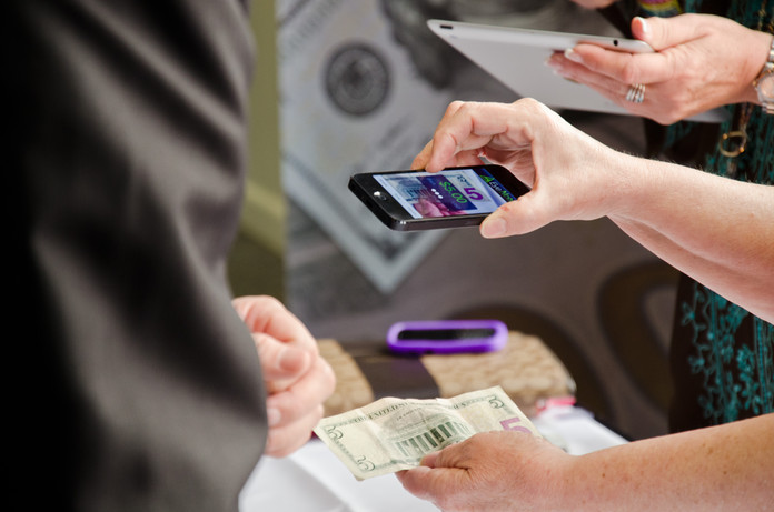 BEP employees demonstrate the EyeNote app at the 2014 Banknote Conference.