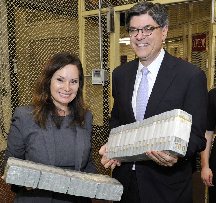Secretary of the Treasury Jacob Lew and Treasurer of the United States Rosie Rios holding bricks of $100 notes.