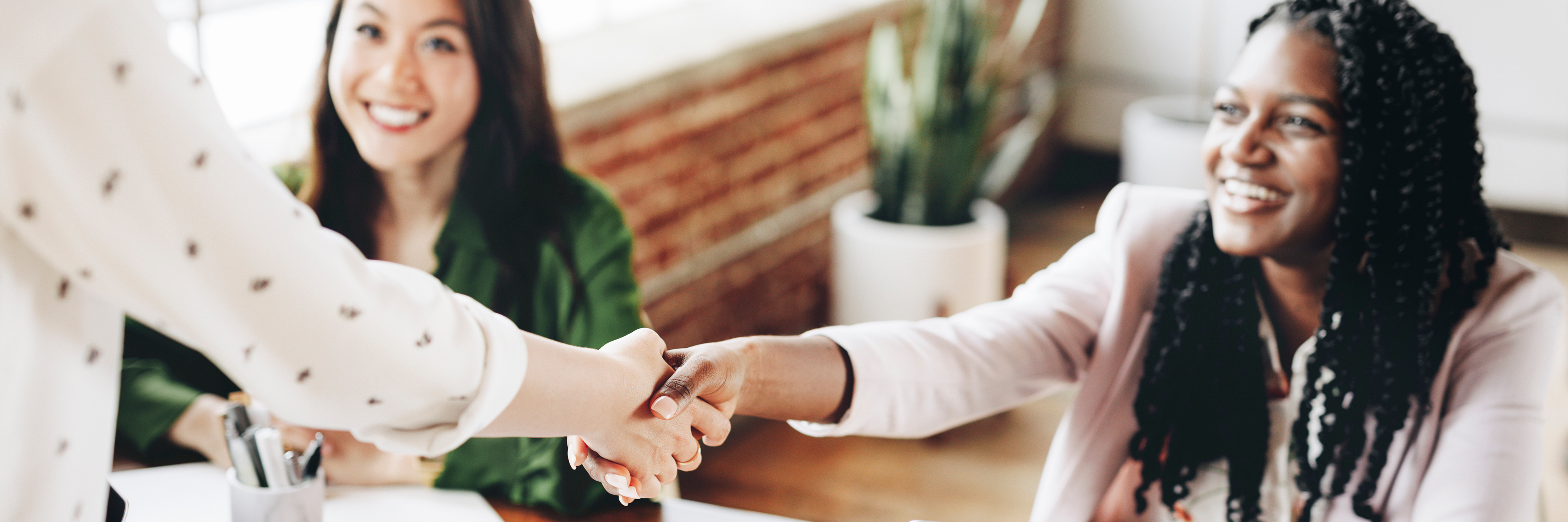 Two women shaking hands in a professional environment