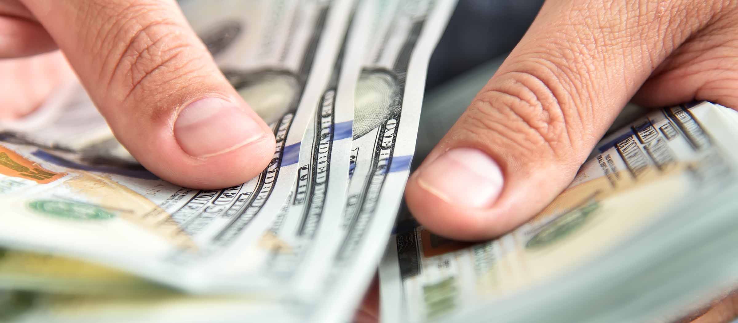 Hands counting stack of bills