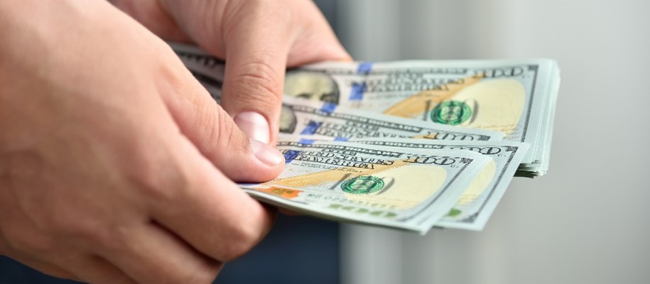Two hands holding a $20.