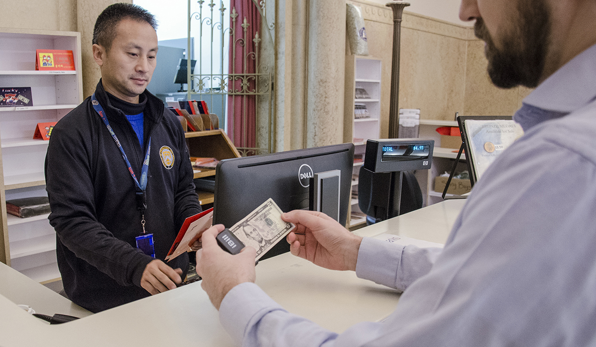 iBill currency reader reading $5 bill at checkout counter